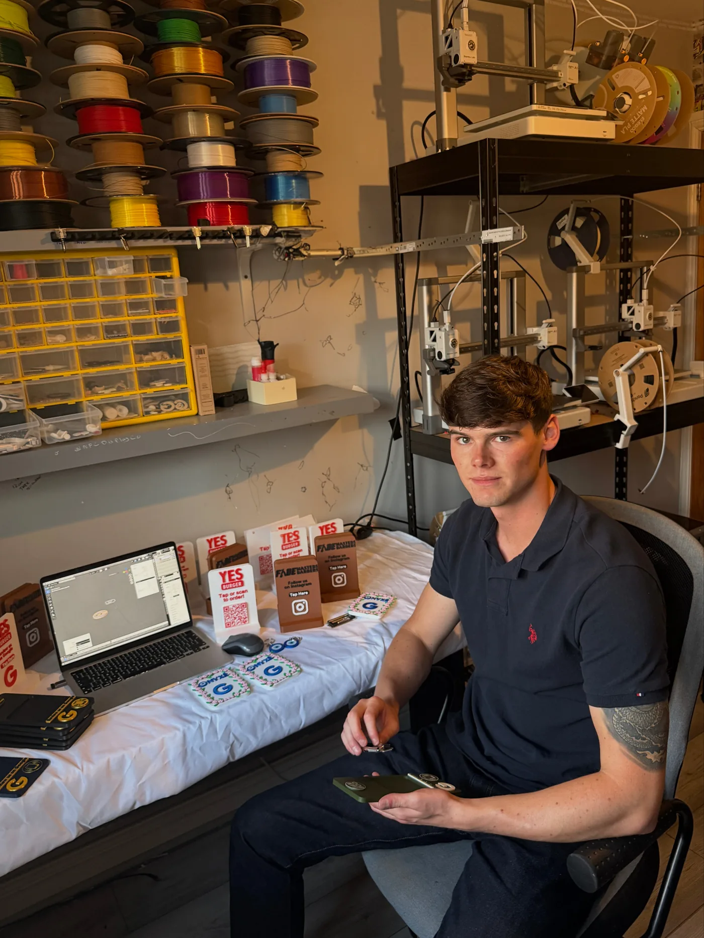 Willem Stones working at his bench surrounded by filament spools and finished NFC displays